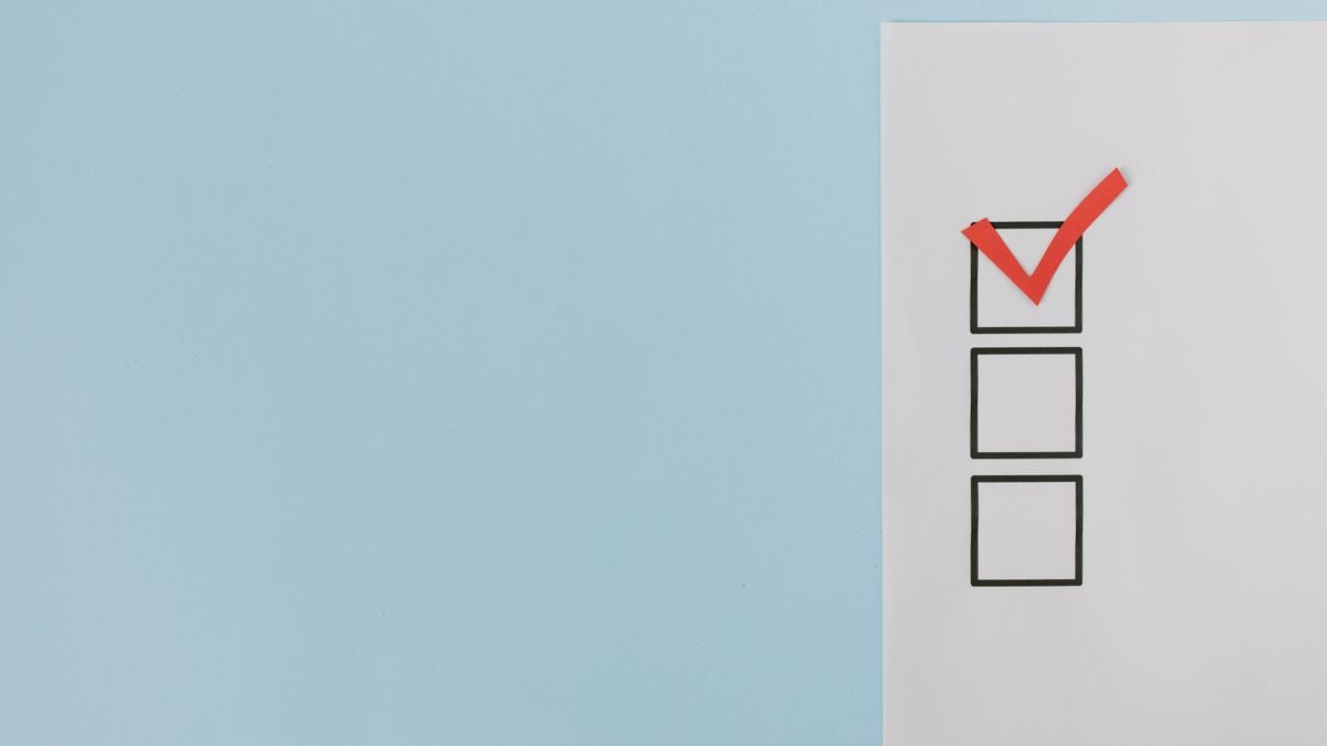 A minimalist checklist with a red checkmark on a blue background, providing ample copy space.