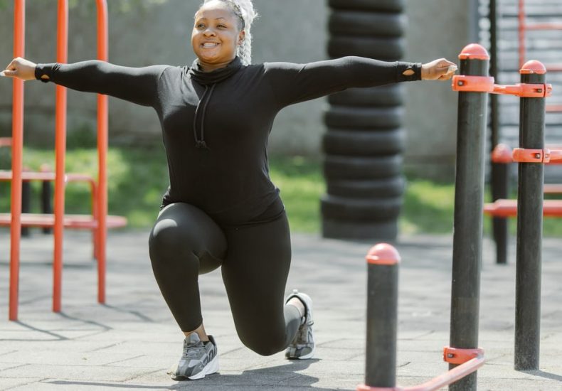 African American woman exercising in a park, promoting a healthy lifestyle.